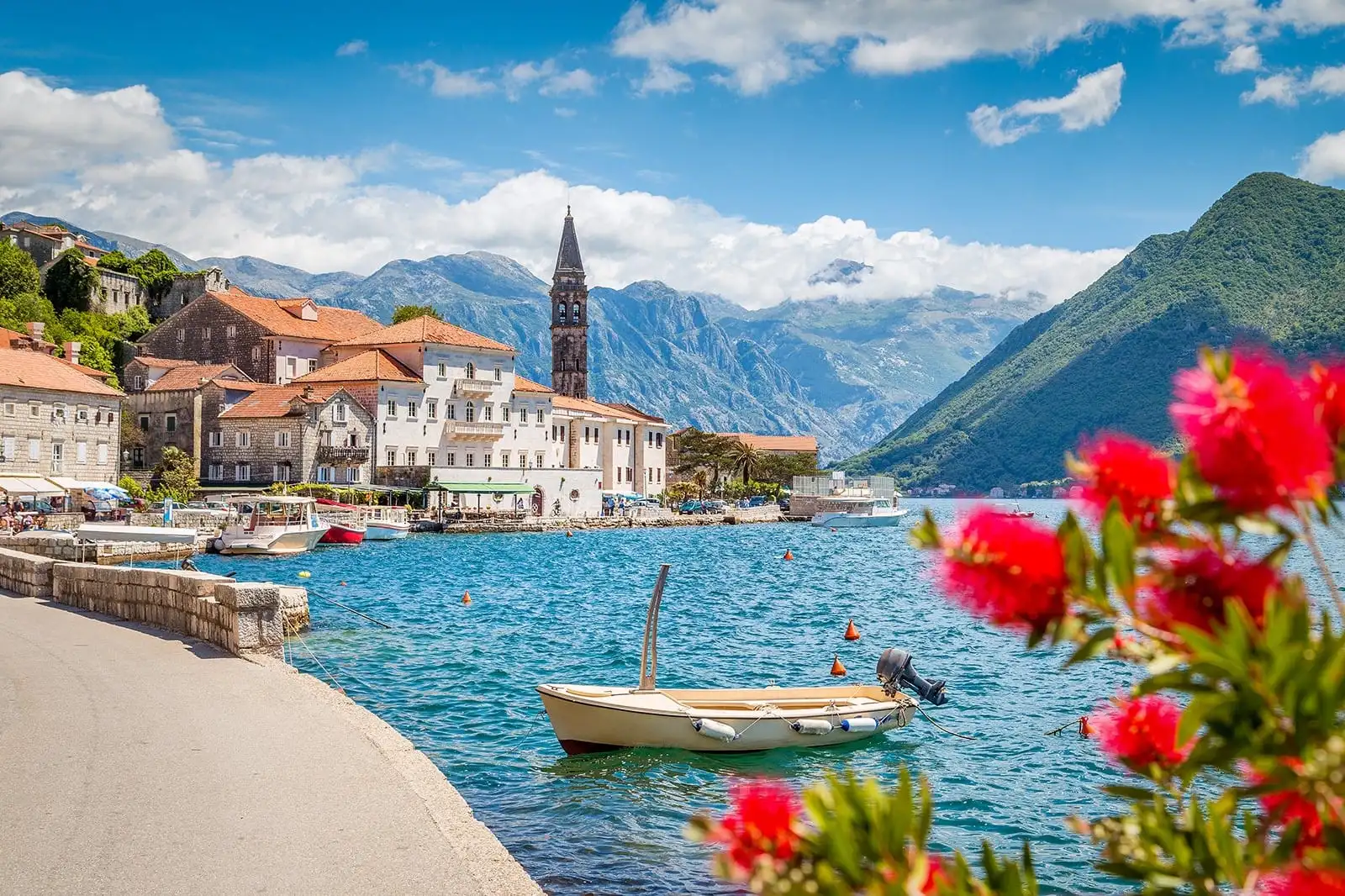 Montenegro sea and town with a small wooden boat in centre frame